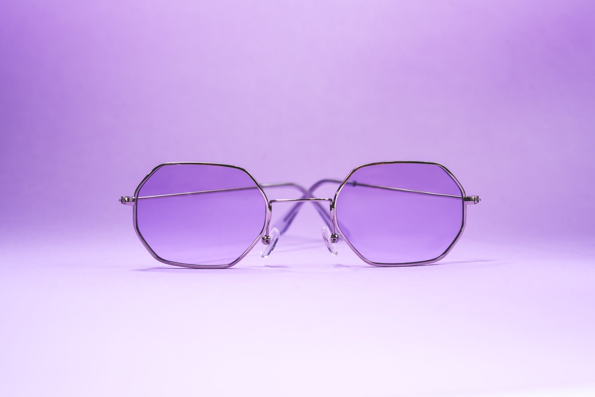 Purple sun glasses on the purple background.